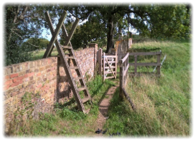 Ladder stile and a kissing gate giving access to the Woodhall Park estate